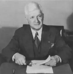 the article subject dressed in a jacket and necktie, seated