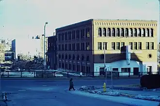A brick Romanesque building being demolished