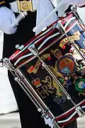 In British military tradition, side drums were increasingly decorated throughout the 19th century, until it bore the fully embellished regimental colours, including its battle honours. As such drums are often afforded respect.