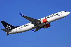 A medium-sized twin jetliner with a black tail and a white body