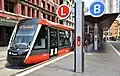 Tram at a light rail stop on the street
