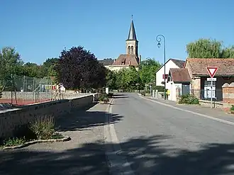 View of Saint-Aubin-le-Monial from Rue des Écoles, and the Saint-Barnabé church in the second ground.