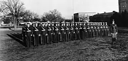Group photograph of members of a military drill team standing at attention