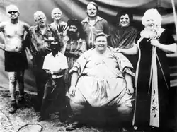 Sideshow performers of Strates Shows, with Melvin Burkhart pictured (back row, third from left, holding his swallowing swords).