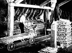 One of the 125 ton lead furnaces (1900), with lead or lead-silver bullion that has been cast, using the ingot moulds on the trolley.