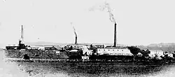 The Dapto Smelting Works in 1900. The tallest chimney (on right) is the smelter chimney and the building in front of it is the smelter building.