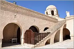 Stairs to the roof, with the Kufic inscription band visible along the top of the wall