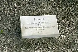 Stone set on the ground inscribed with "Justus, first Bishop of Rochester 604–624, fourth Archbishop of Canterbury 624–627, d. 627"