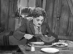 Charlie Chaplin eating a boot in his film The Gold Rush