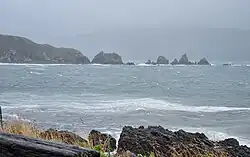 Photo of rocks protruding from ocean.