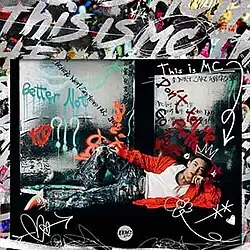 A man wearing a white tank top and a red sweater lies down with his face and body directed towards the front.