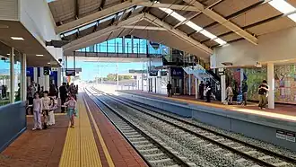 View from bridge of two railway tracks merging into one as they leave the station