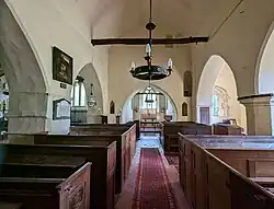 The nave and chancel of St. Andrew's church, at Tichborne, Hampshire, England. September 2024.