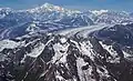 Aerial view of Tokosha Mountains in lower half of frame, with Ruth Glacier and Denali in the distance