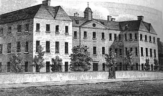 black and white image of large 3-storey building with lots of windows