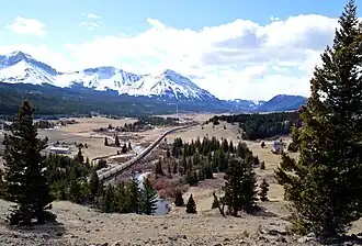 A train heads west toward the summit of the Crowsnest Pass from Coleman, Alberta.