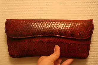 Clutch with fold-over closure, made of red snakeskin