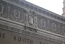 Detail of the facade on 45th Street. The brick section of the facade is surrounded by a stucco band of sgraffito decorations, which is painted beige and contains bas reliefs of classical-style foliate ornamentation.