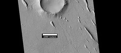 Yardangs near a crater, as seen by HiRISE under HiWish program Location is in the Amazonis quadrangle.