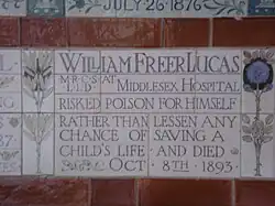 A tablet formed of five tiles of varying sizes, bordered by yellow and blue flowers in an art nouveau style