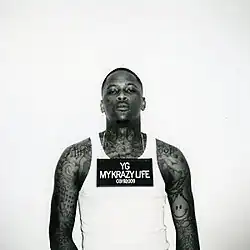 A mugshot image of YG in black and white while wearing a necklace with a mugshot sign reading "YG MY KRAZY LIFE 03192009".