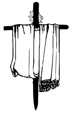 The darfash, the symbol of Mandaeism. It consists of an olive wooden cross draped with a white cloth and adorned with seven myrtles branches.