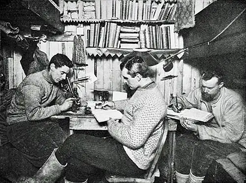 Photo of a man seated close together in a nook framed by bunks
