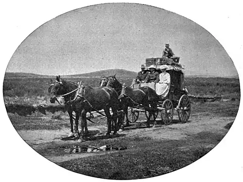 Coach and horses on barren landscape, three passengers in front