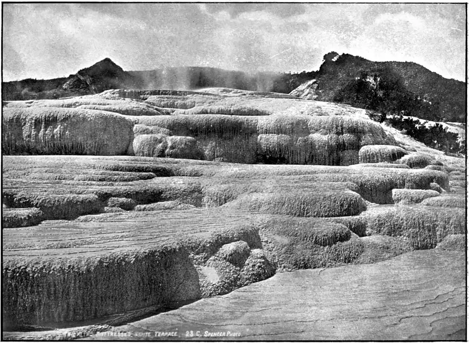"Terraced buttresses with water flowing down, and hills in the background"