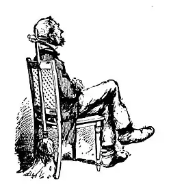 Man sitting on a chair posing for a photo with legs and arms crossed