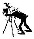 Photographer with head under cover with camera on a tripod