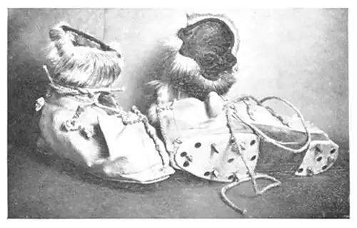 Photograph of a pair of fur boots with removable metal ice cleats
