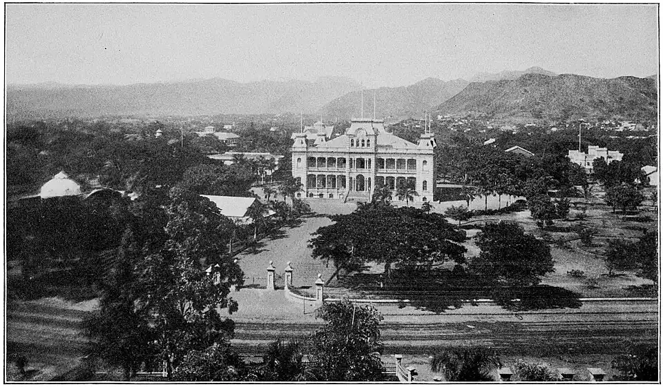 A large white palace surrounded by woods