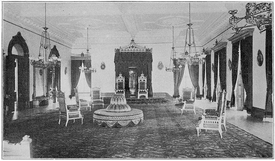 A large room with a throne in the back