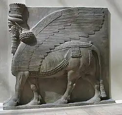 Assyrian relief sculpture of a Lamassu - a winged bull with a bearded human head