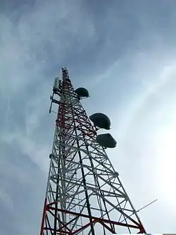 A photograph at a close, upward angle of a radio tower.