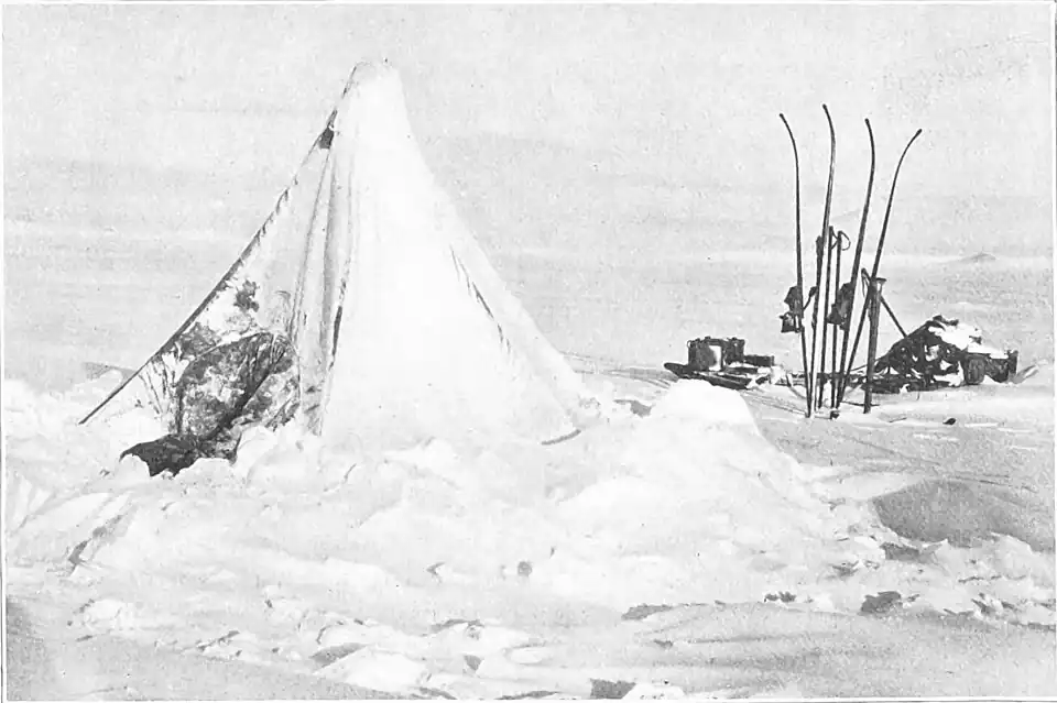 Photo of a conical tent weighed down with caked snow