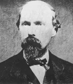 Black and white photograph of a balding man with a beard