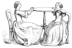 Sketch showing two mediums making a table float: one of them lifts it with her foot and then they keep it in the air by pressing against it from opposite sides.