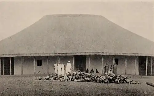 A small crowd in front of a large house