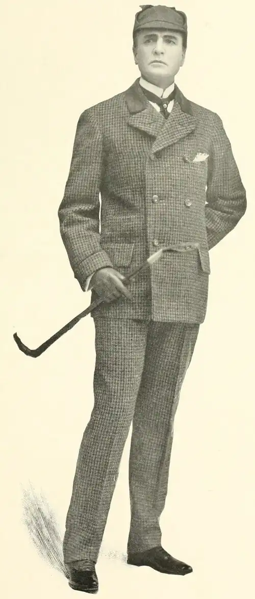 William Gillette as Sherlock Holmes, standing, dressed in [describe suit], wearing a deerstalker cap and holding a walking stick.