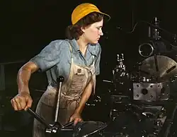 Photograph of a woman working in a factory, machining aircraft parts, in 1942.
