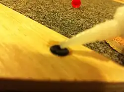 Photo 6:Putting a small amount of Crazy Glue in the grommet to hold the pin in place.