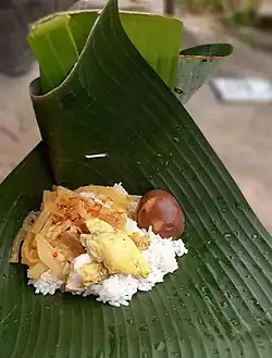 Eating individually by holding a layer of banana leaf.