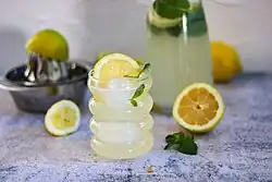fancy lemon drink, showing citrus reamer and other bar equipment in the background